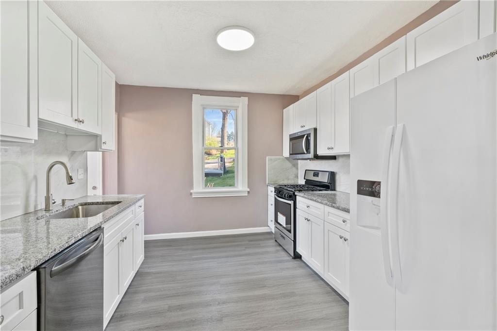 711 9th Avenue Irwin, PA 15642 - Photo 11 of 26 a kitchen with granite countertop a sink stove a refrigerator and a stove