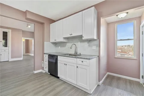 a kitchen with granite countertop white cabinets and white appliances