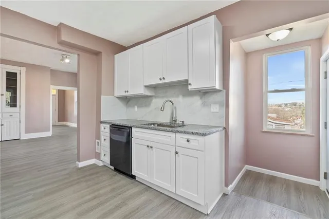 a kitchen with granite countertop white cabinets and white appliances
