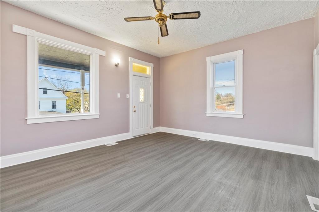 711 9th Avenue Irwin, PA 15642 - Photo 5 of 26 a view of an empty room with wooden floor and a window