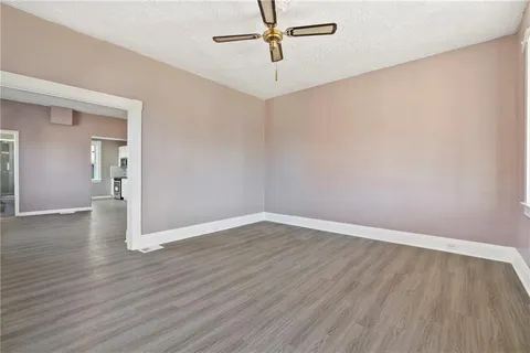 a view of an empty room with wooden floor