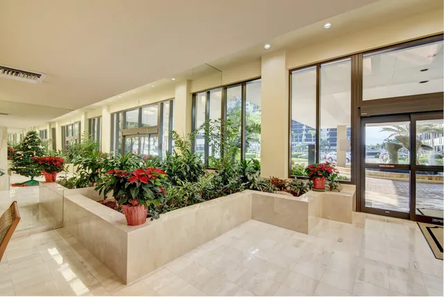 a lobby with a flower garden and furniture