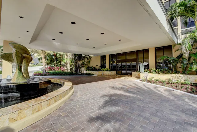 a swimming pool with outdoor seating and potted plants