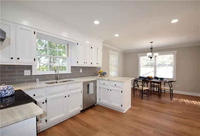 a kitchen with granite countertop a sink dining table chairs and window