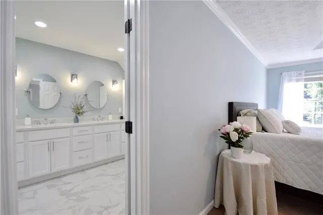 a bathroom with a granite countertop tub a double vanity sink and mirror