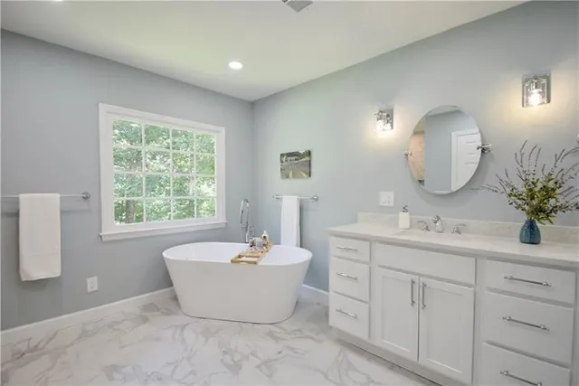 a bathroom with a granite countertop sink a toilet a large mirror and shower
