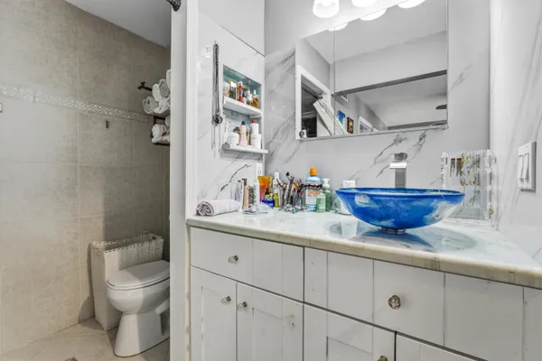 a bathroom with a granite countertop sink a toilet and a shower