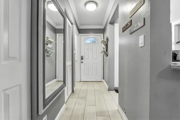 a view of a hallway with wooden floor and a bathroom