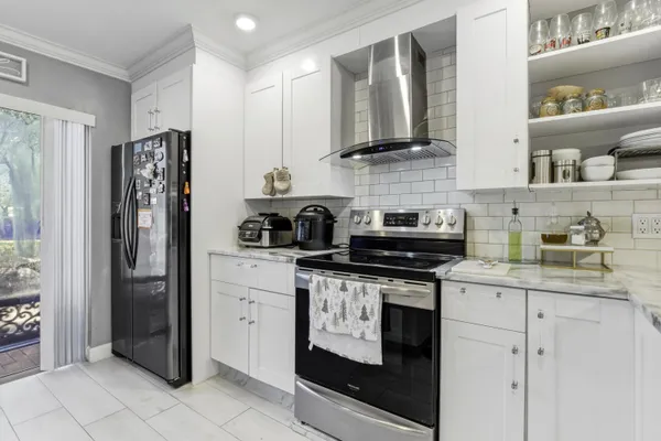 a kitchen with stainless steel appliances granite countertop white cabinets and refrigerator