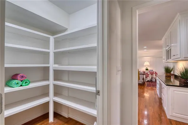 a view of a hallway with wooden floor and a window