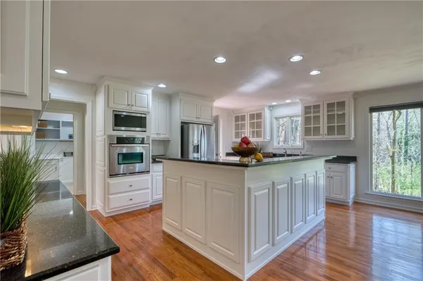 a kitchen with granite countertop a refrigerator and a living room