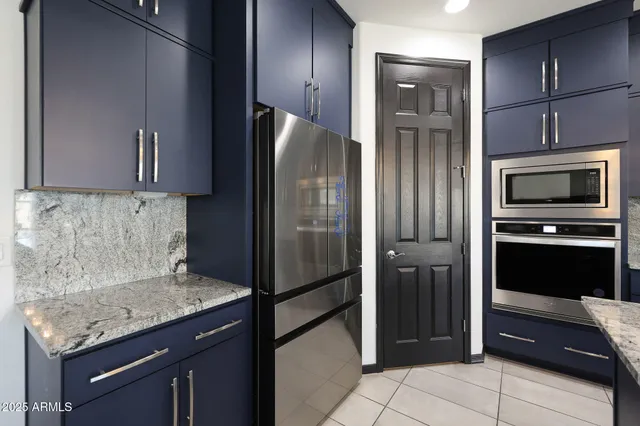 a large kitchen with kitchen island a sink a counter top space and stainless steel appliances