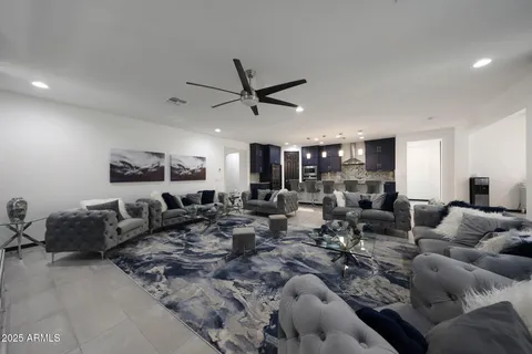 a living room with lots of furniture and a ceiling fan