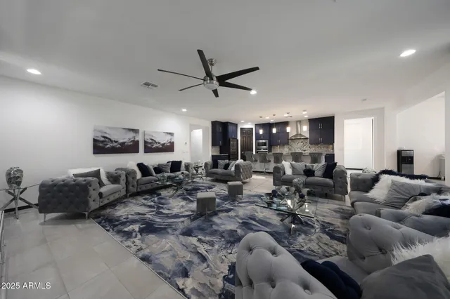 a living room with lots of furniture and a ceiling fan
