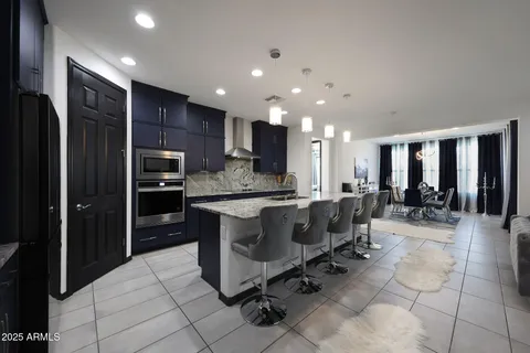 a large kitchen with a large counter top stainless steel appliances and cabinets