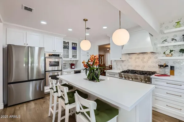 a kitchen with a stove a refrigerator and a dining table with wooden floor