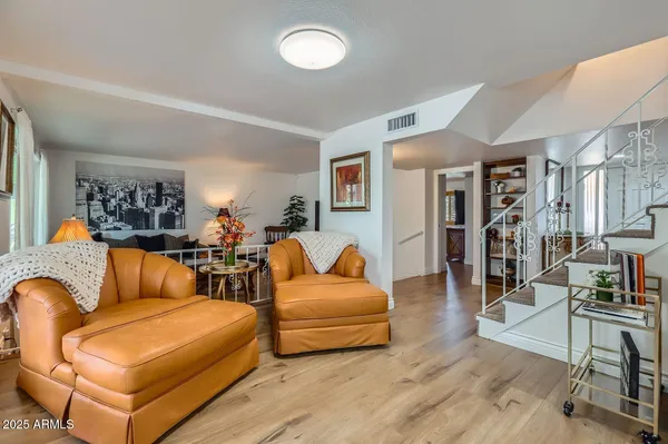 a living room with furniture and a wooden floor