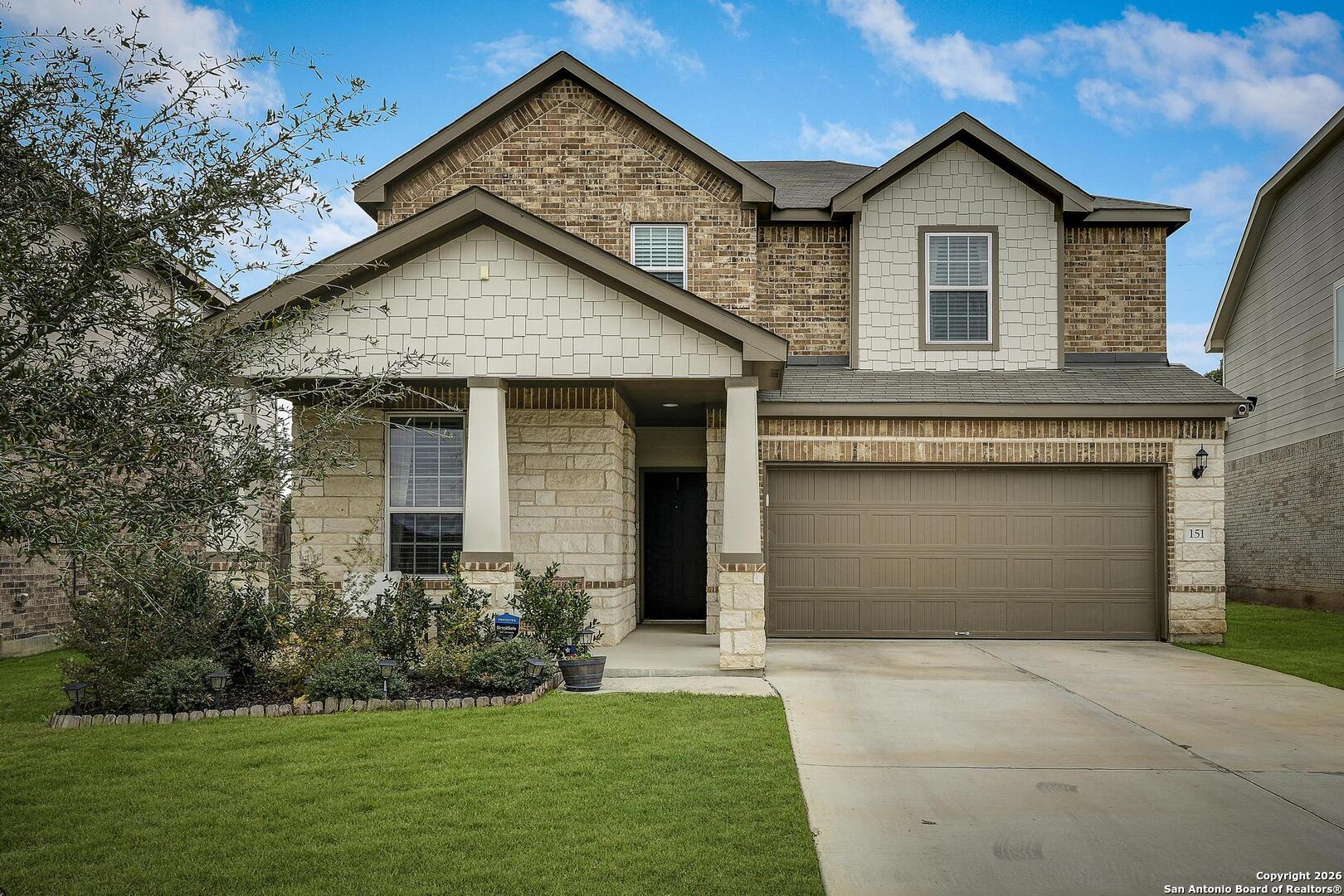 a front view of a house with a yard and garage