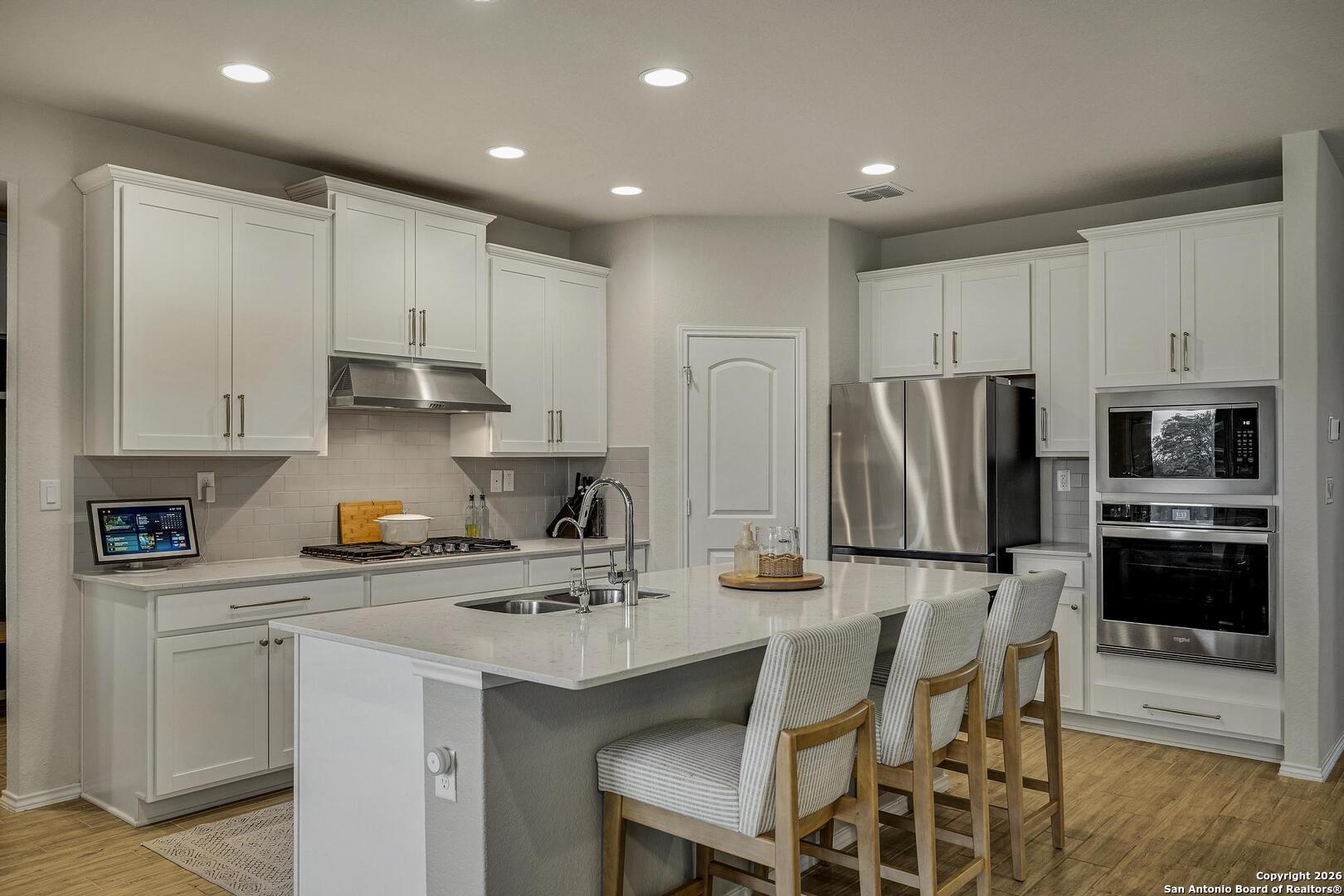 151 Inverness Boerne, TX 78015 - Photo 9 of 31 a kitchen with stainless steel appliances a sink a stove a refrigerator cabinets and a dining table