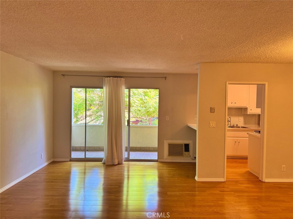 5625 North Sumner Way, Unit 212 Culver City, CA 90230 - Photo 13 of 39 a view of empty room with wooden floor and fireplace