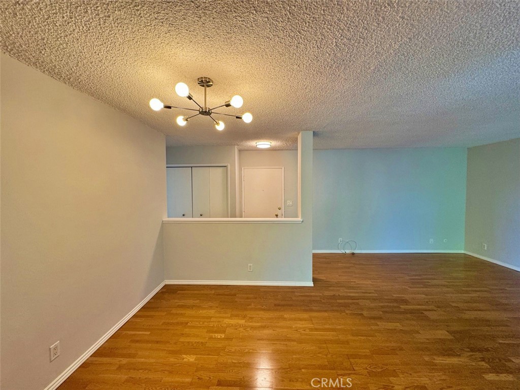 5625 North Sumner Way, Unit 212 Culver City, CA 90230 - Photo 9 of 39 a view of an empty room with chandelier fan and kitchen view