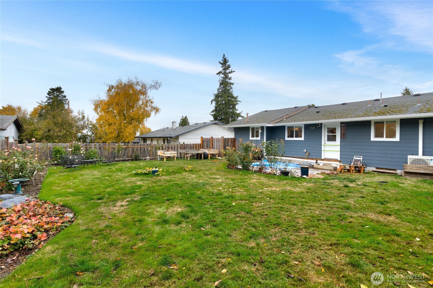 2304 E Avenue Anacortes, WA 98221 - Photo 24 of 26 a backyard of a house with table and chairs plants and large tree