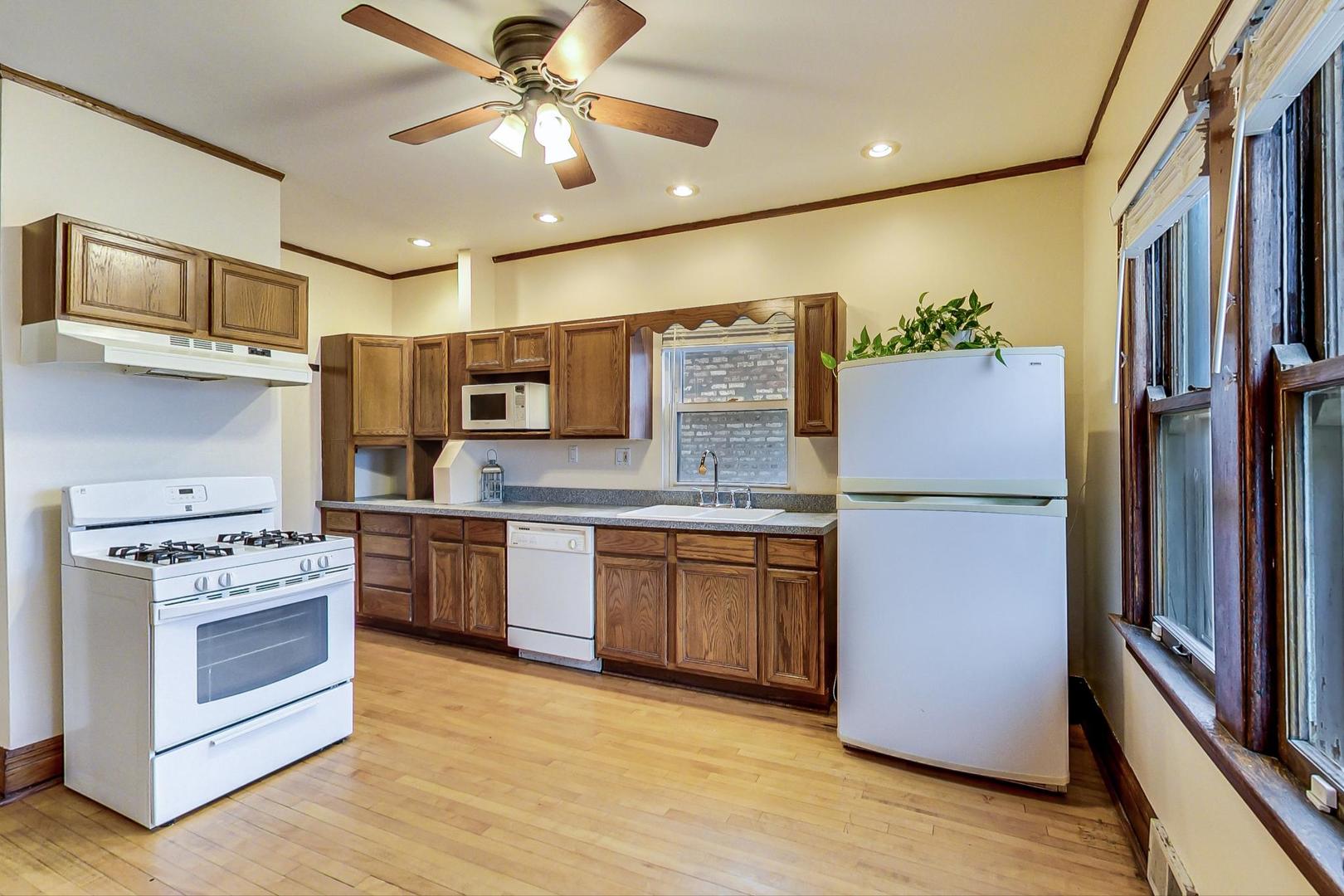 6522 28th Street Berwyn, IL 60402 - Photo 11 of 45 a kitchen with stainless steel appliances granite countertop a stove refrigerator sink and microwave