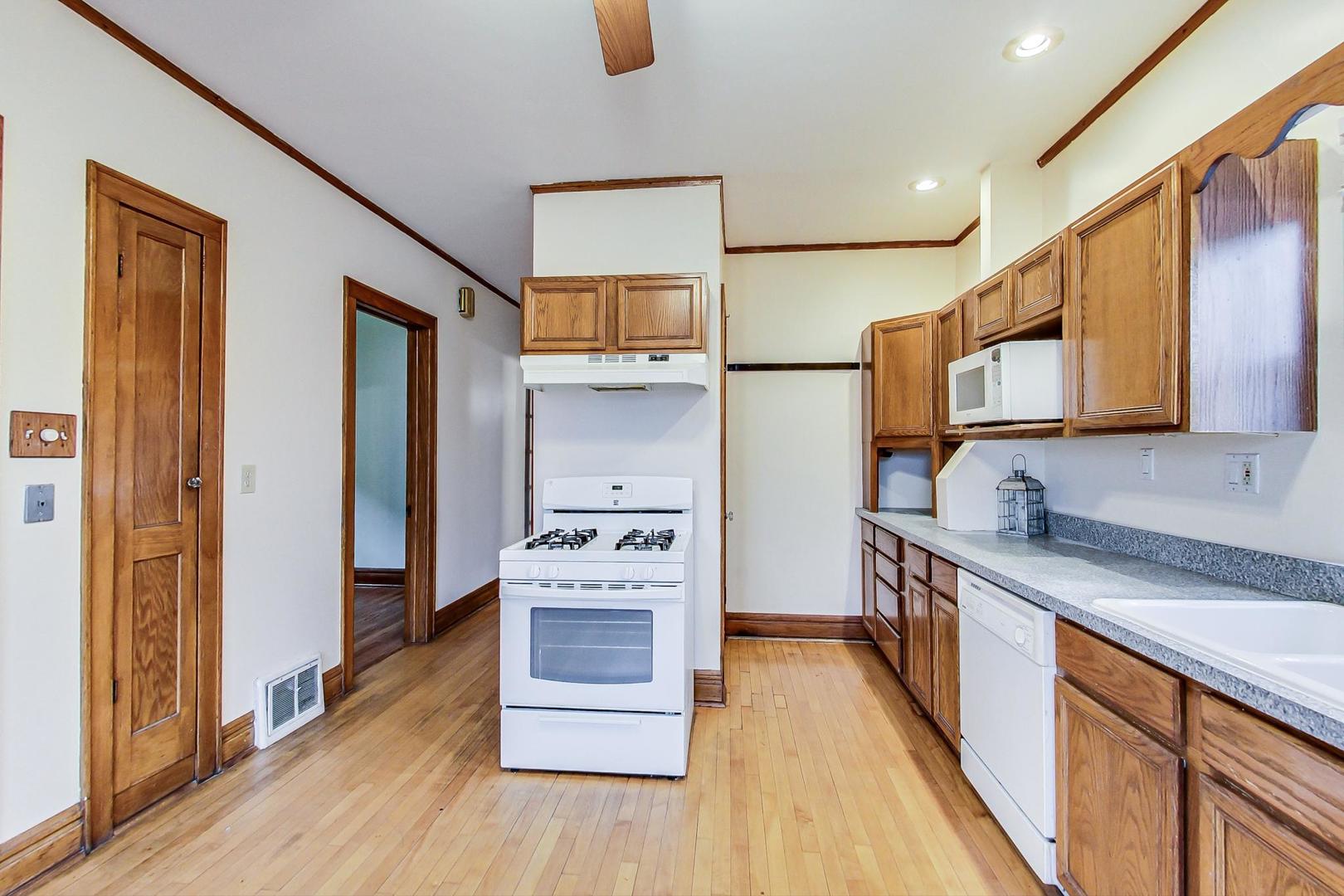 6522 28th Street Berwyn, IL 60402 - Photo 12 of 45 a kitchen with stainless steel appliances granite countertop a stove a sink and a refrigerator