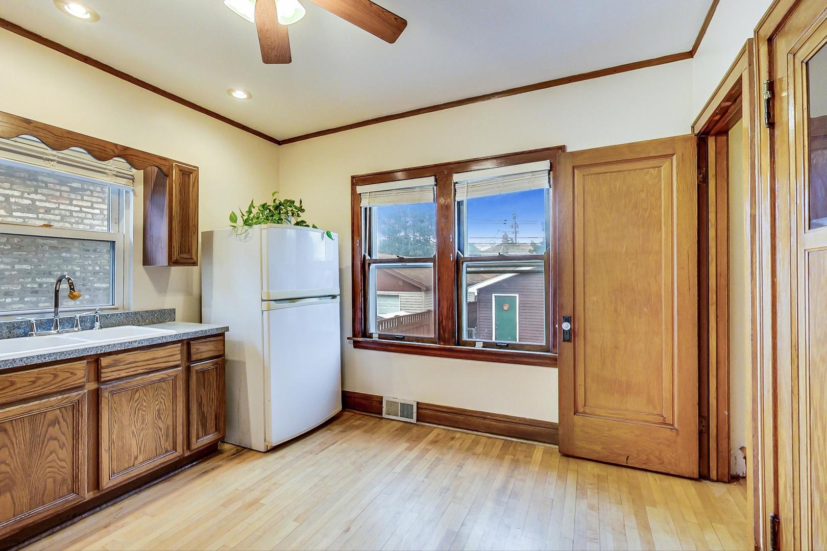 6522 28th Street Berwyn, IL 60402 - Photo 10 of 45 a view of a kitchen with a fridge wooden floor and a ceiling fan
