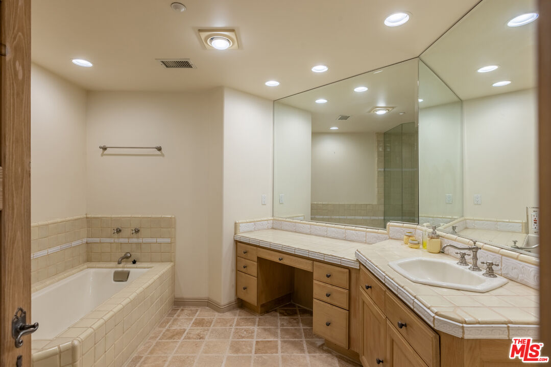 1041 Somera Road Los Angeles, CA 90077 - Photo 25 of 40 a bathroom with a tub sink double vanity granite and a bathtub