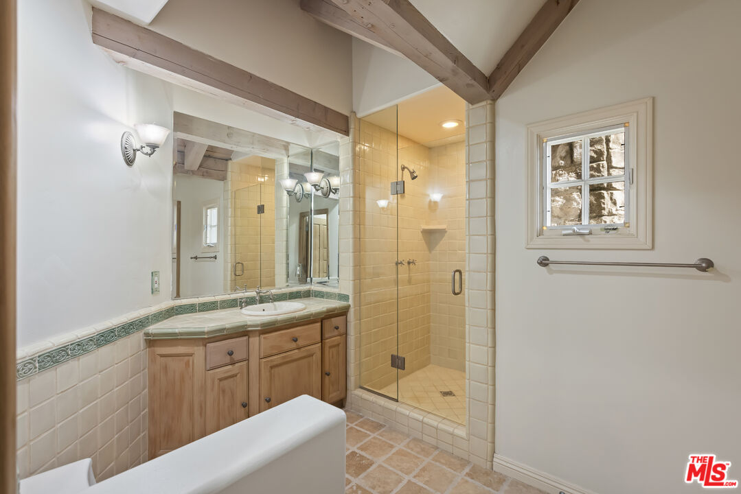 1041 Somera Road Los Angeles, CA 90077 - Photo 27 of 40 a bathroom with a granite countertop sink a mirror a bathtub and shower