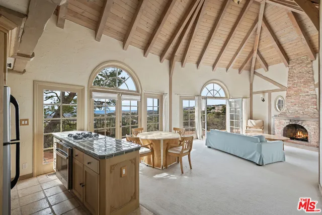 a living room with furniture a fireplace and a floor to ceiling window