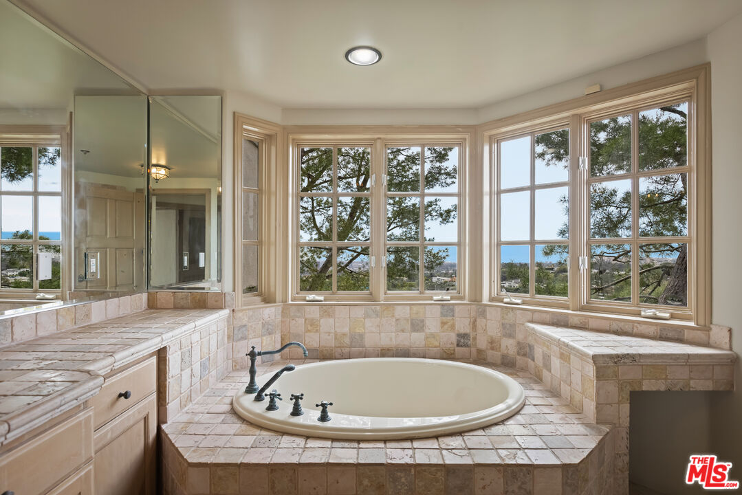 1041 Somera Road Los Angeles, CA 90077 - Photo 35 of 40 a bathroom with a granite countertop tub and a sink