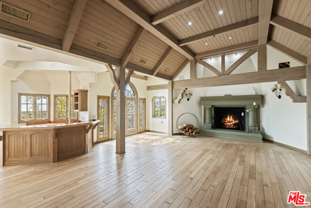 1041 Somera Road Los Angeles, CA 90077 - Photo 8 of 40 a view of an empty room with wooden floor fireplace and a window