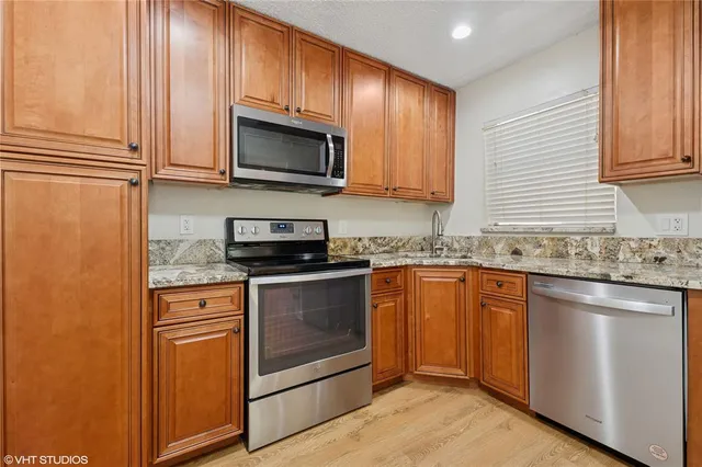 a kitchen with granite countertop stainless steel appliances and white cabinets