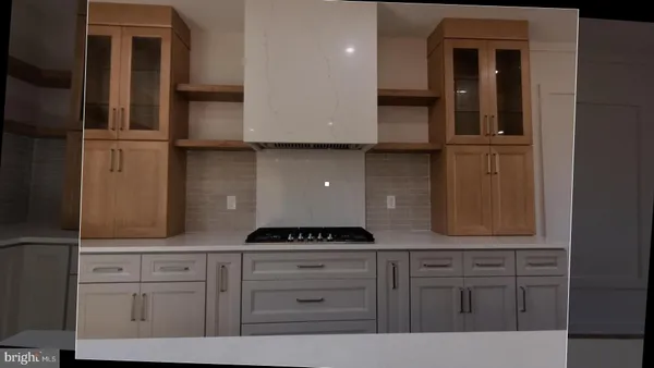a kitchen with white cabinets and sink