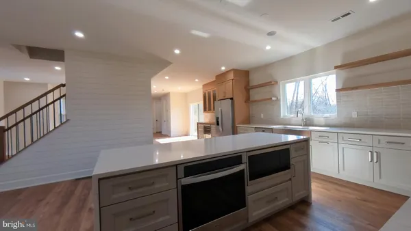a kitchen with stainless steel appliances granite countertop a sink a stove a counter space and cabinets