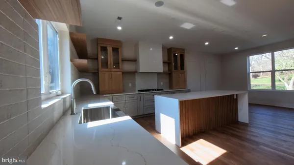 a kitchen with stainless steel appliances granite countertop a sink a stove and a wooden floors