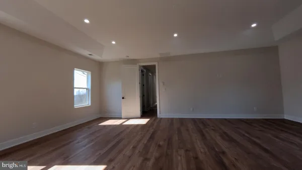 an empty room with wooden floor and window