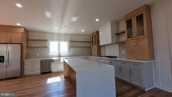 a kitchen with stainless steel appliances granite countertop a sink a stove and refrigerator