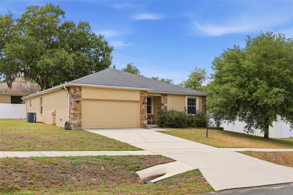 306 Stone Point Lane Lady Lake, FL 32159 - Photo 11 of 39 a front view of a house with a yard and garage