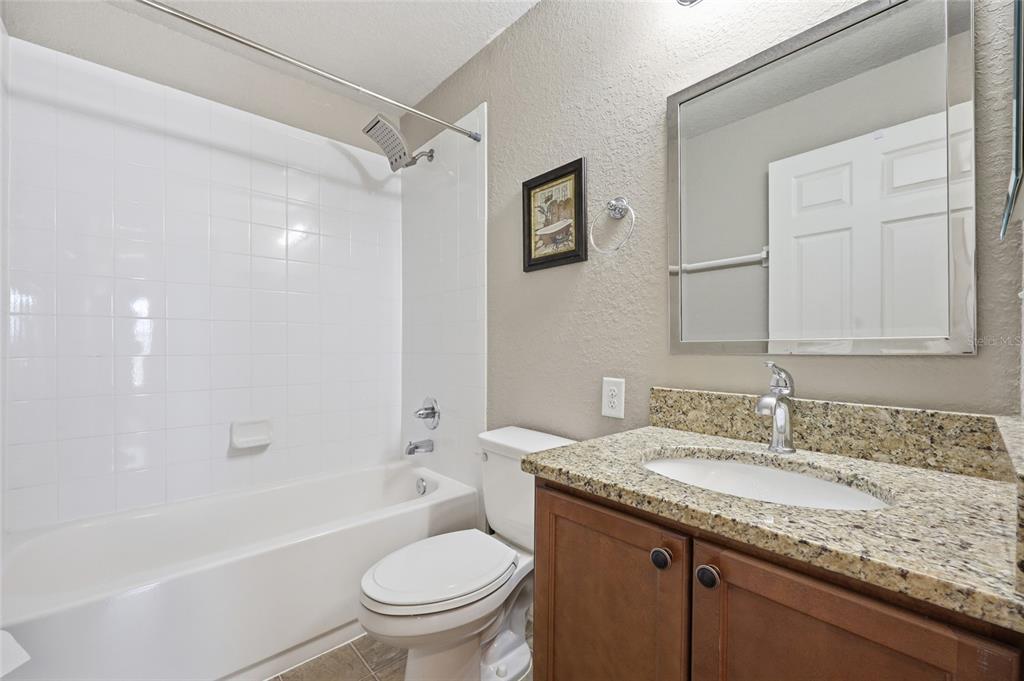 306 Stone Point Lane Lady Lake, FL 32159 - Photo 18 of 39 a bathroom with a granite countertop sink toilet and shower