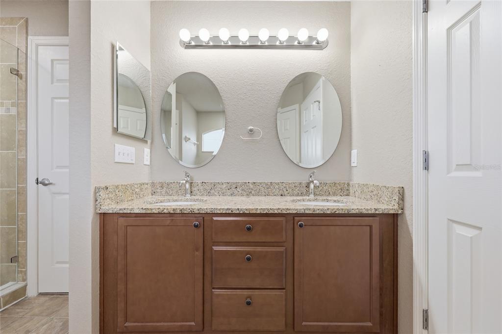 306 Stone Point Lane Lady Lake, FL 32159 - Photo 27 of 39 a bathroom with a granite countertop double vanity sink and a mirror
