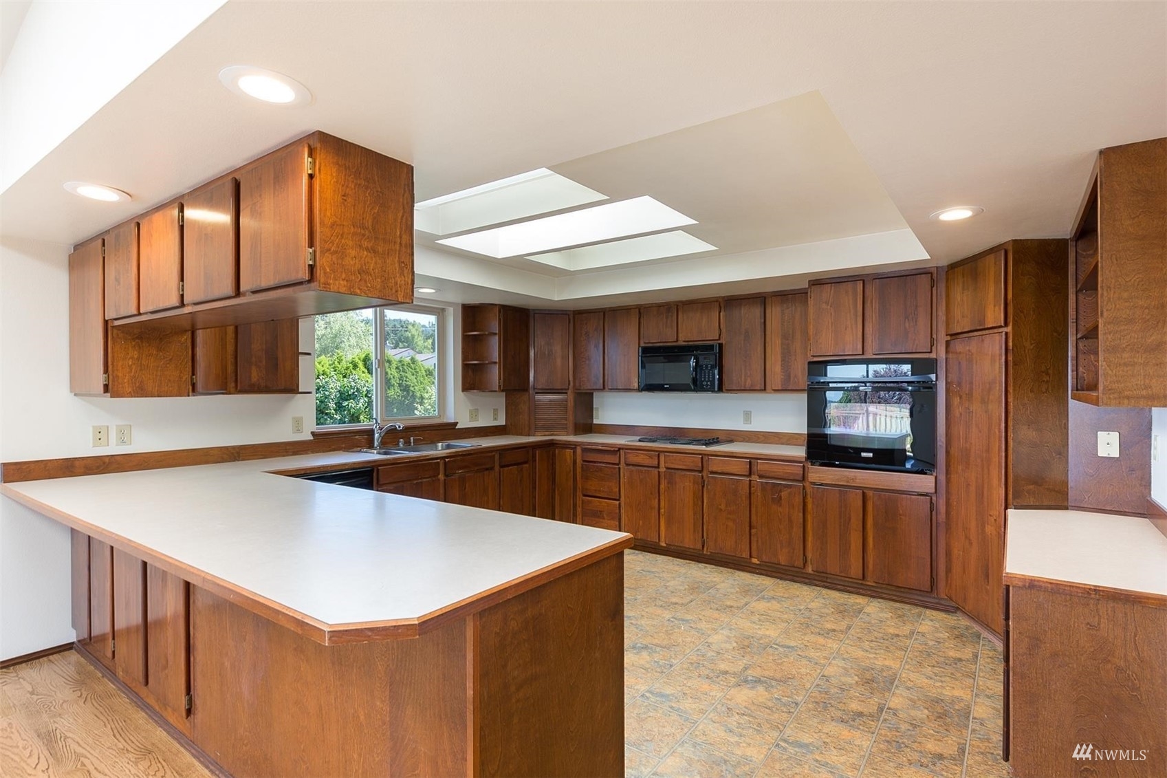 308 Eunice Street Sequim, WA 98382 - Photo 23 of 38 a kitchen with stainless steel appliances granite countertop a sink a stove top oven a refrigerator a kitchen island and couches with wooden floor