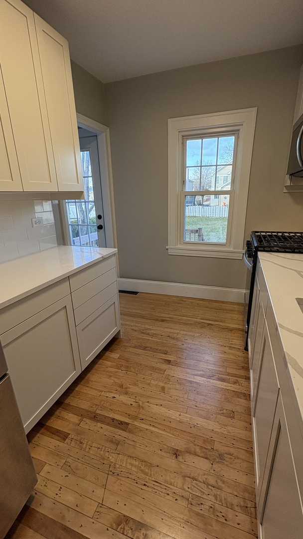 421 East Indiana Street Wheaton, IL 60187 - Photo 32 of 37 a view of an empty room with window and hardwood floor