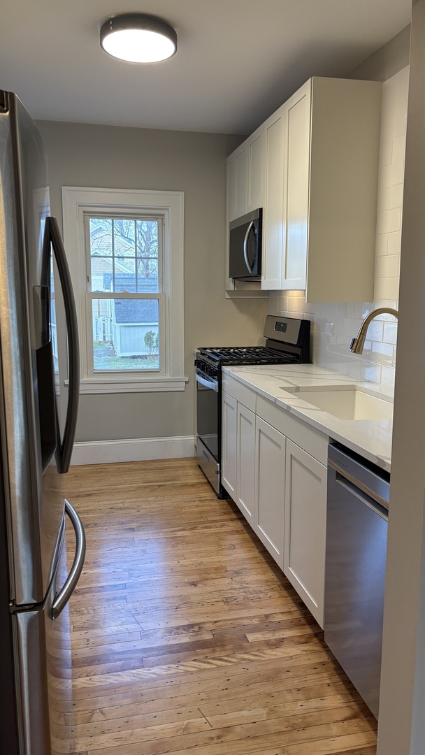 421 East Indiana Street Wheaton, IL 60187 - Photo 36 of 37 a kitchen with stainless steel appliances granite countertop a sink stove and refrigerator