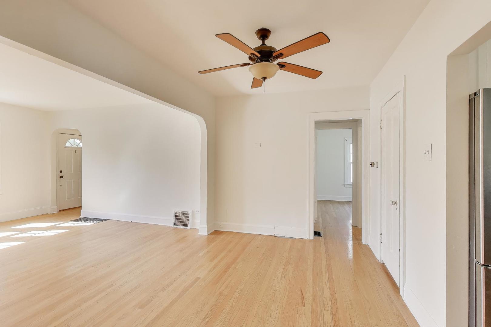 421 East Indiana Street Wheaton, IL 60187 - Photo 5 of 37 a view of a big room with wooden floor and a ceiling fan