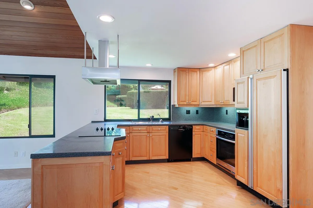 1332 Sun Valley Road Solana Beach, CA 92075 - Photo 12 of 38 a kitchen with stainless steel appliances granite countertop wooden cabinets a stove a sink and a refrigerator