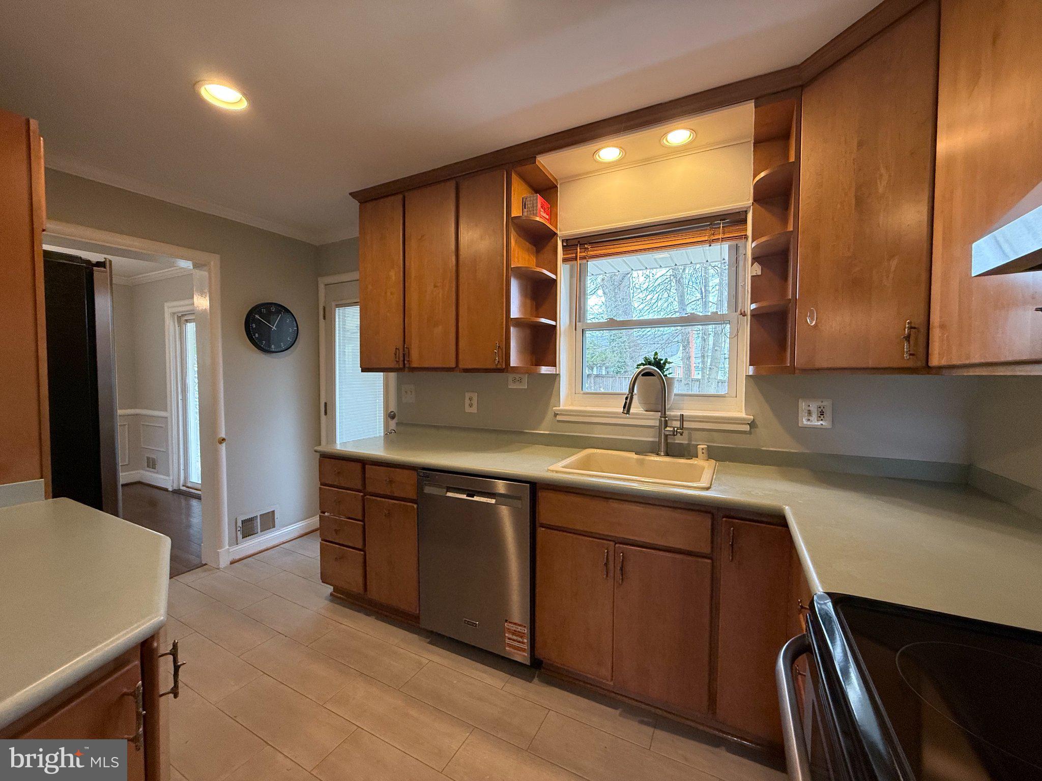 9709 Saxony Road Silver Spring, MD 20910 - Photo 13 of 47 a kitchen with stainless steel appliances a sink stove and cabinets