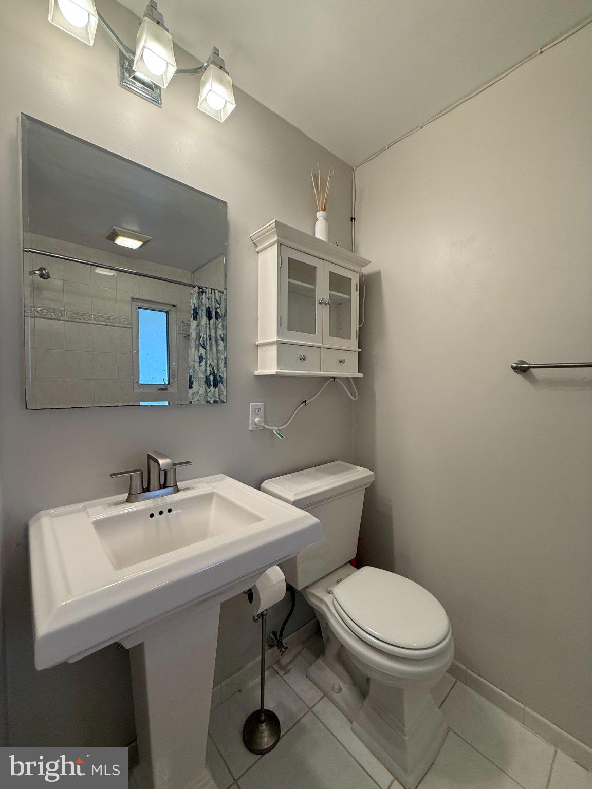 9709 Saxony Road Silver Spring, MD 20910 - Photo 20 of 47 a bathroom with a toilet a sink and mirror